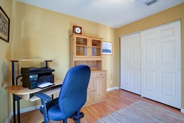 home office with light hardwood / wood-style flooring