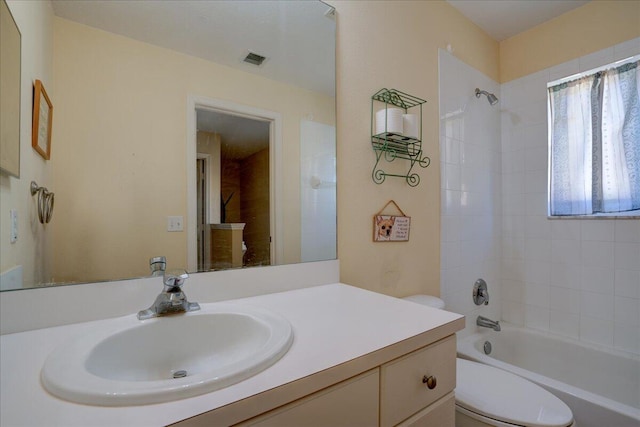 full bathroom with vanity, toilet, and tiled shower / bath combo