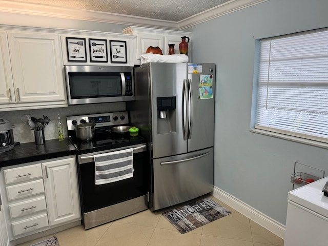 kitchen featuring light tile patterned floors, stainless steel appliances, and white cabinetry