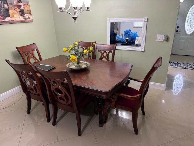 tiled dining room with a chandelier