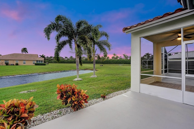 view of yard featuring a patio area, a water view, and ceiling fan