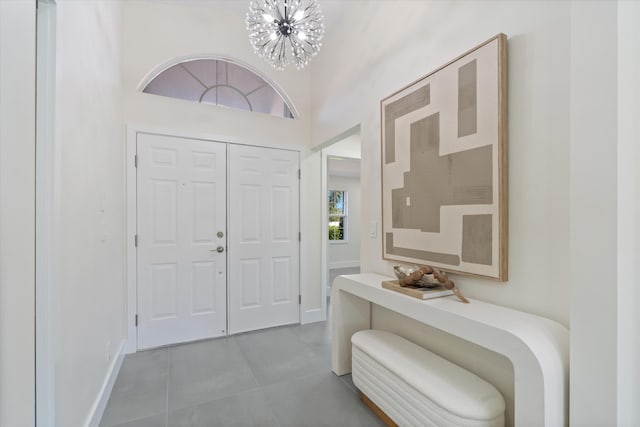 foyer featuring tile patterned flooring, a notable chandelier, and a towering ceiling