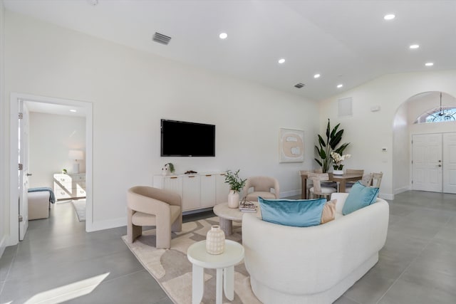 living area with baseboards, visible vents, arched walkways, and recessed lighting