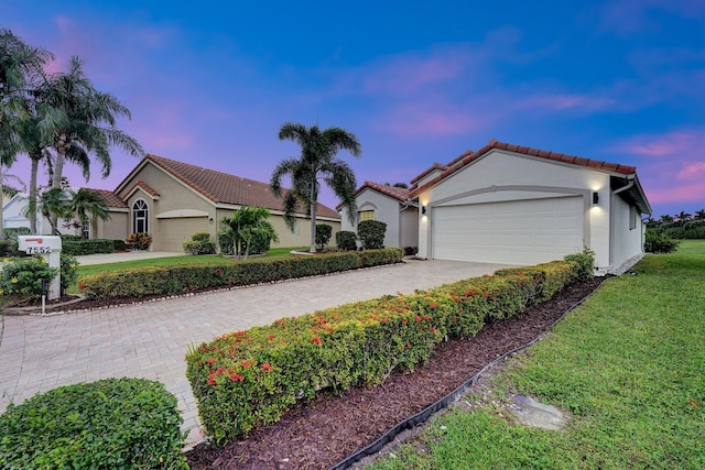 view of front of home with a yard and a garage