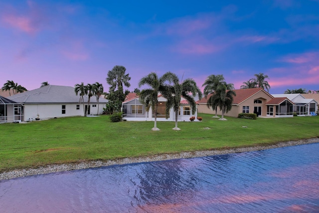 ranch-style house with a yard and a water view