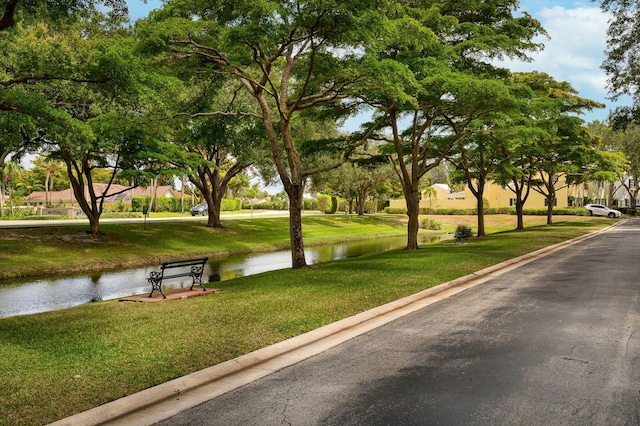 view of community with a lawn and a water view