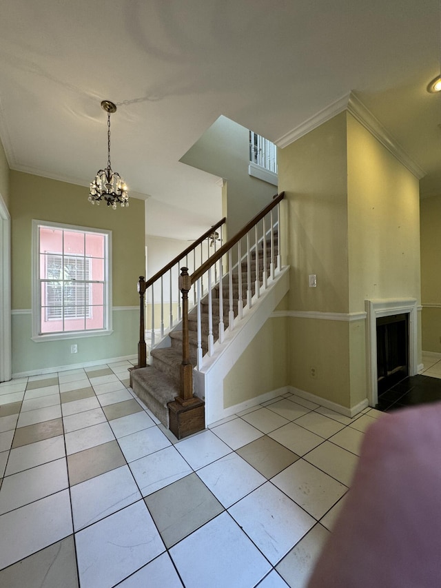 stairs with tile patterned flooring, an inviting chandelier, and crown molding