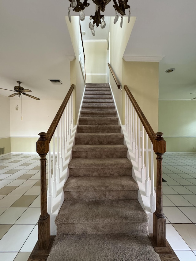 stairway with crown molding, tile patterned flooring, and ceiling fan