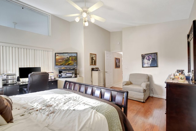 bedroom featuring ceiling fan, a high ceiling, and light hardwood / wood-style flooring