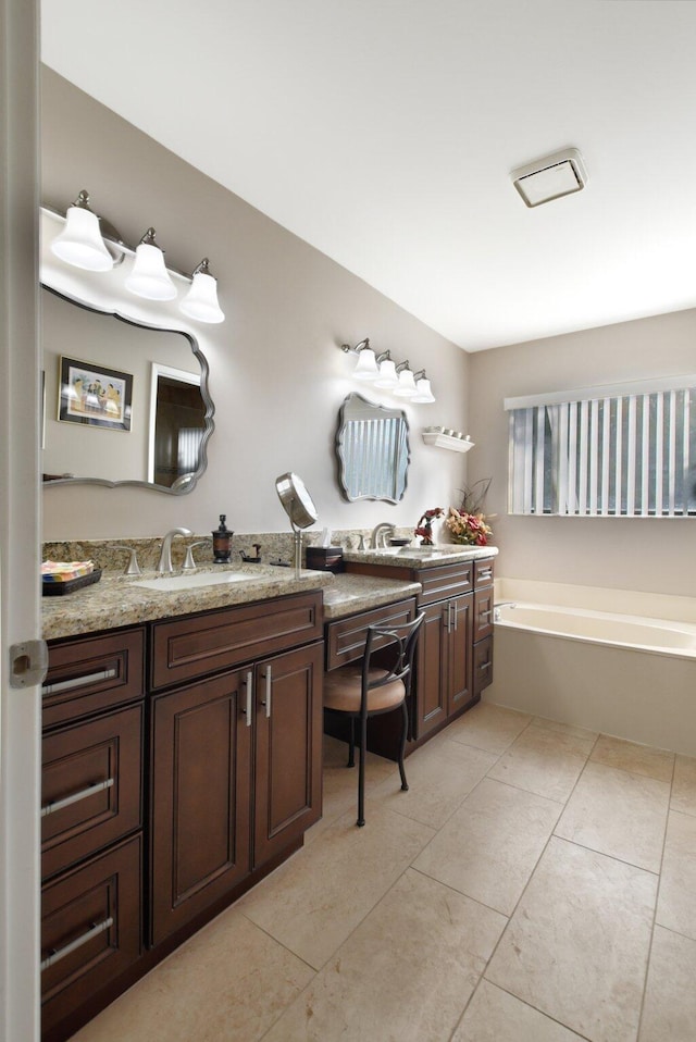 bathroom with tile patterned flooring, vanity, and a tub