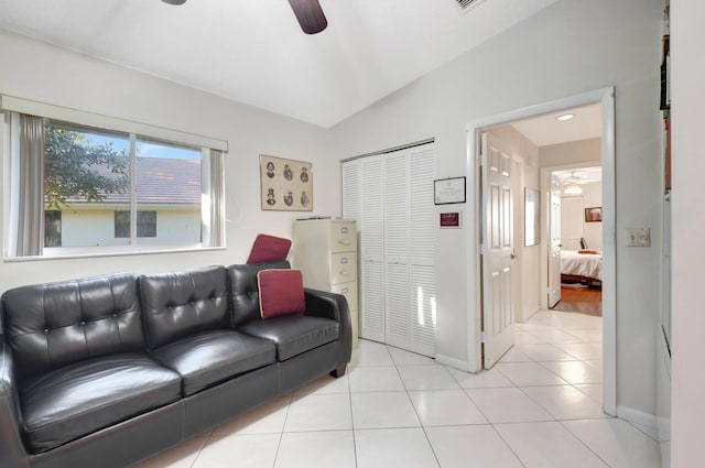 tiled living room with ceiling fan and vaulted ceiling