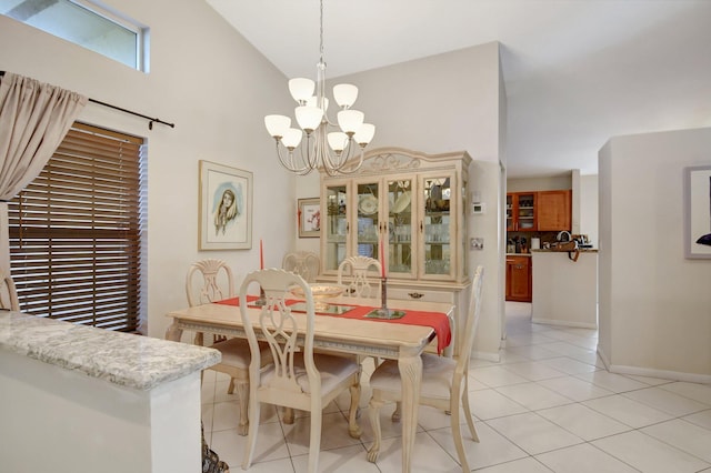 tiled dining area featuring a chandelier and high vaulted ceiling