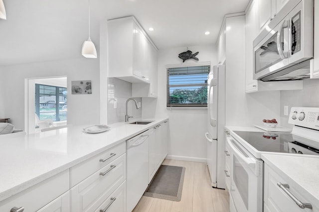 kitchen featuring white cabinets, white appliances, decorative light fixtures, and sink