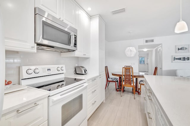 kitchen with white cabinets, decorative light fixtures, electric stove, and tasteful backsplash