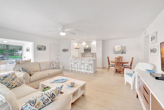 living room featuring light wood-type flooring and ceiling fan