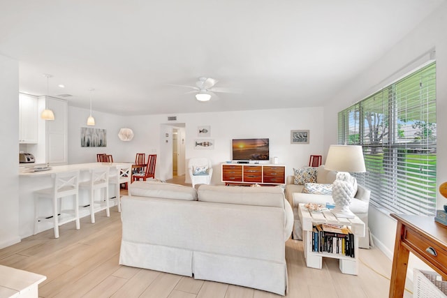 living room with light wood-type flooring and ceiling fan