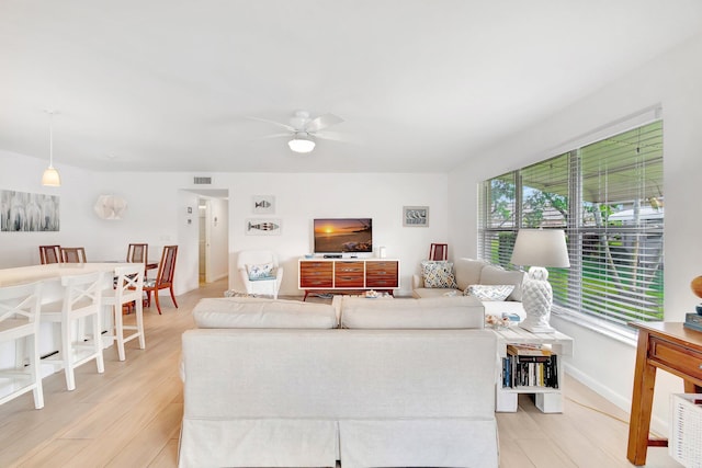 living room with light hardwood / wood-style floors and ceiling fan