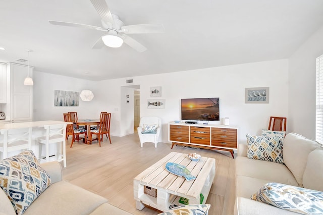 living room with ceiling fan and light hardwood / wood-style flooring