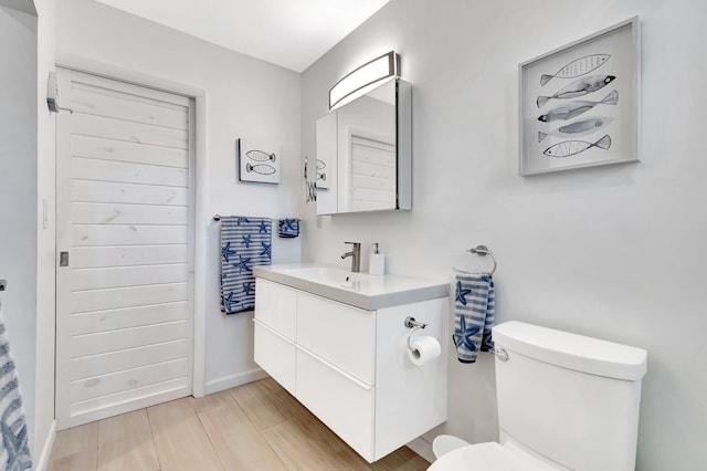 bathroom with hardwood / wood-style floors, vanity, and toilet