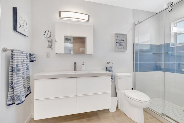 bathroom featuring vanity, toilet, wood-type flooring, and walk in shower