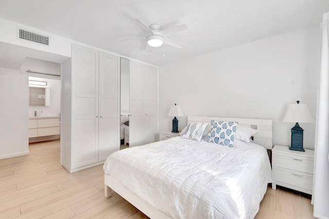 bedroom with a closet, light hardwood / wood-style floors, and ceiling fan