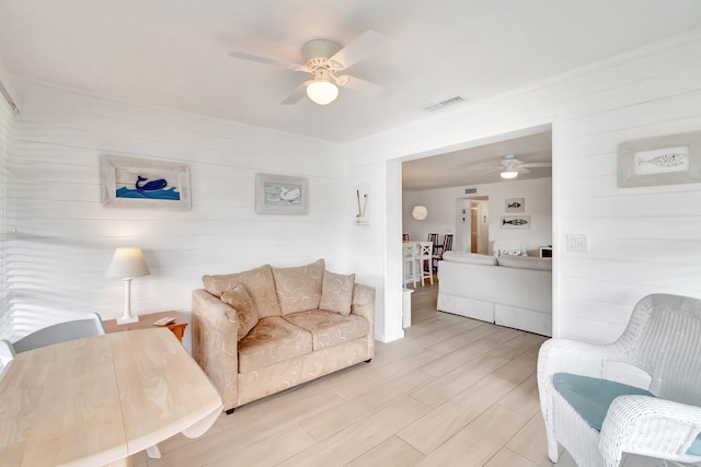 living room featuring ceiling fan and light hardwood / wood-style floors