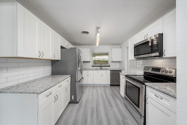 kitchen featuring white cabinets, light hardwood / wood-style floors, sink, and stainless steel appliances