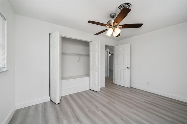 unfurnished bedroom featuring ceiling fan, a closet, and light wood-type flooring