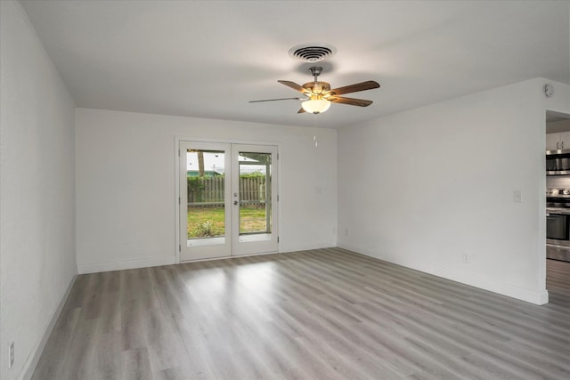 spare room featuring ceiling fan, french doors, and light hardwood / wood-style flooring