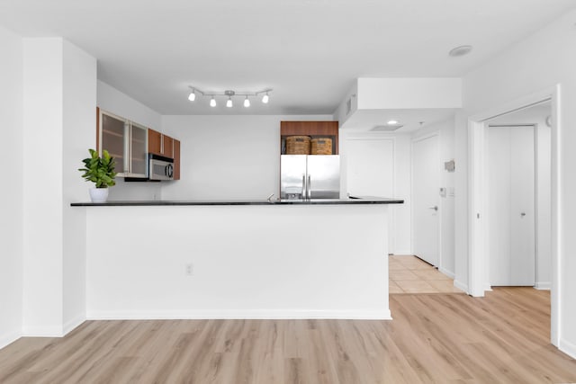 kitchen featuring kitchen peninsula, light hardwood / wood-style floors, and appliances with stainless steel finishes