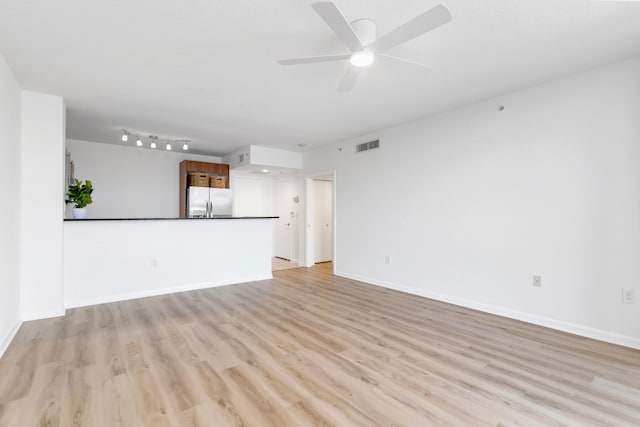 unfurnished living room featuring ceiling fan and light hardwood / wood-style floors