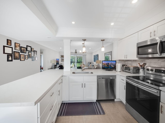 kitchen with white cabinetry, kitchen peninsula, sink, and appliances with stainless steel finishes