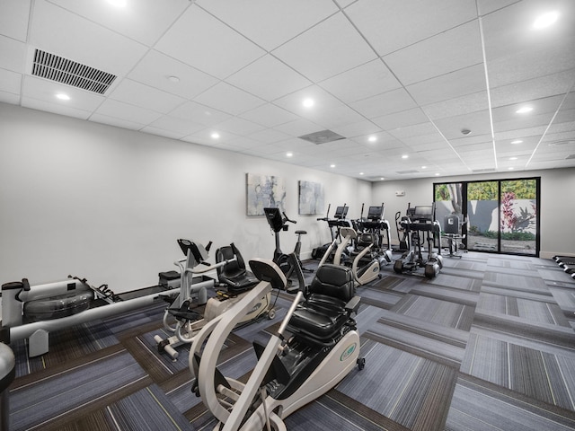 workout area featuring a paneled ceiling and carpet flooring