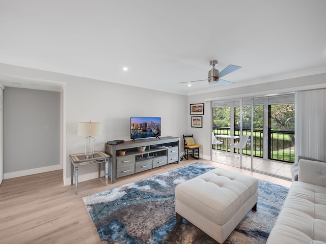 living room with light hardwood / wood-style flooring, ceiling fan, and ornamental molding