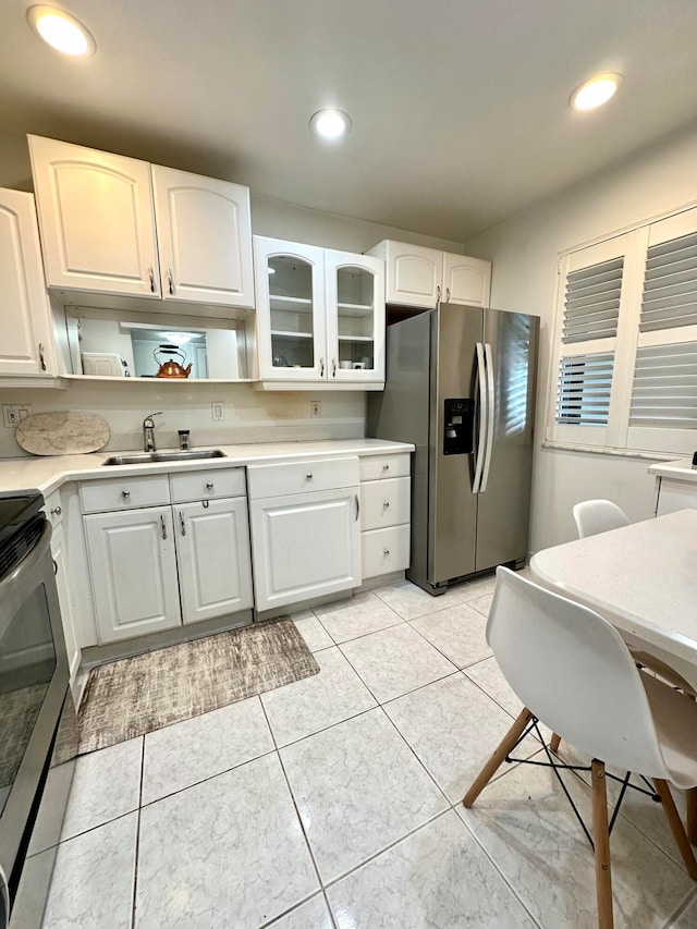 kitchen featuring white cabinets, light tile patterned flooring, sink, and stainless steel appliances