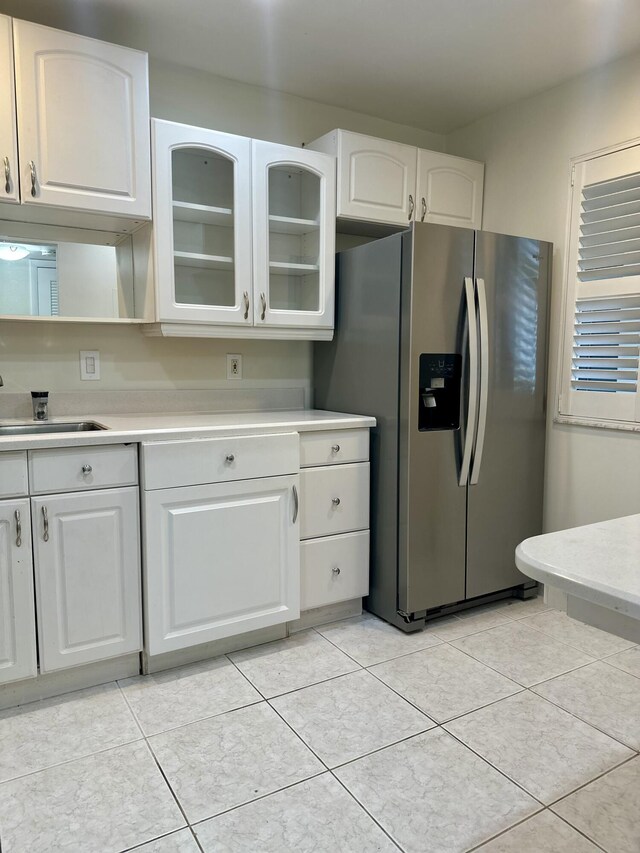 kitchen featuring electric range, white cabinetry, stacked washer / drying machine, and sink