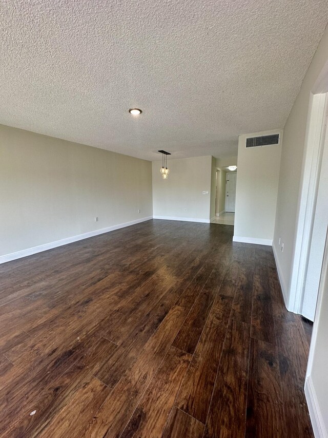 living room featuring dark hardwood / wood-style flooring and a textured ceiling