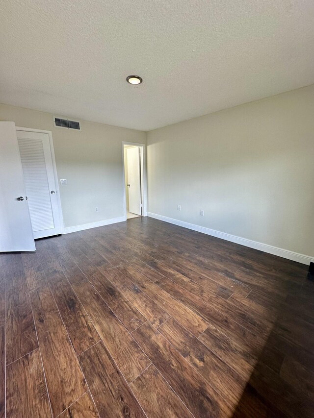 living room featuring a textured ceiling and dark hardwood / wood-style floors