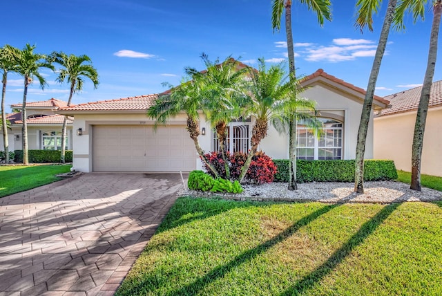 mediterranean / spanish-style home with a garage and a front lawn