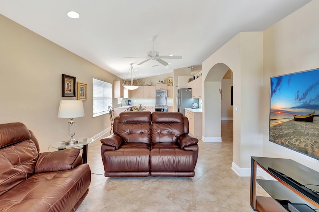 living room featuring ceiling fan, lofted ceiling, and light tile patterned floors