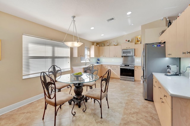 dining room with sink, light tile patterned floors, and lofted ceiling