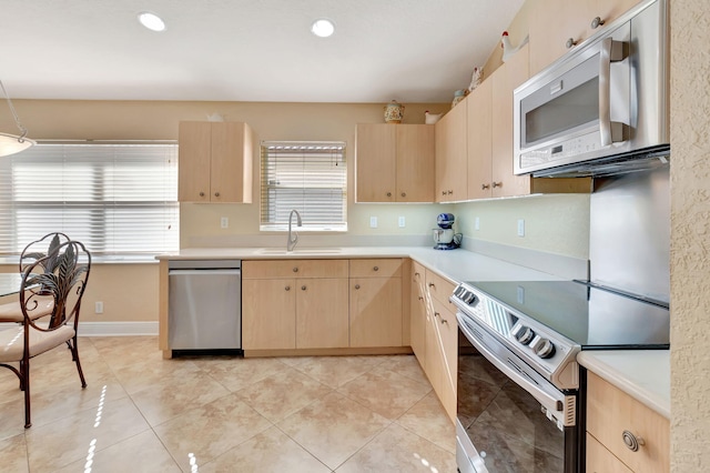 kitchen with light brown cabinets, sink, light tile patterned floors, and stainless steel appliances