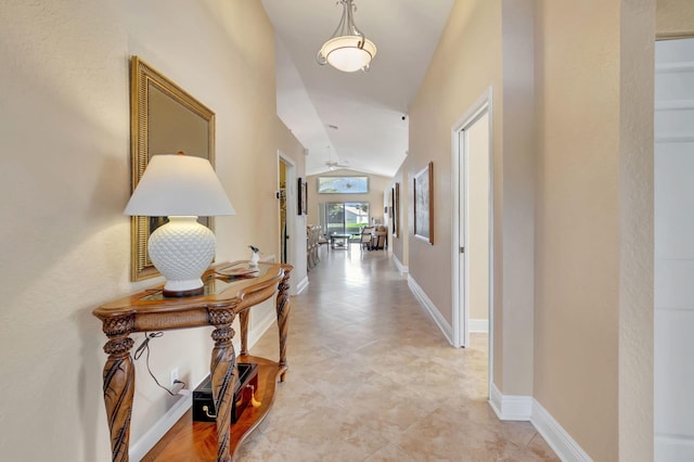 corridor with light tile patterned floors and vaulted ceiling