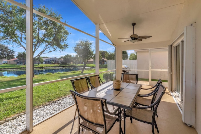 sunroom featuring a water view and ceiling fan