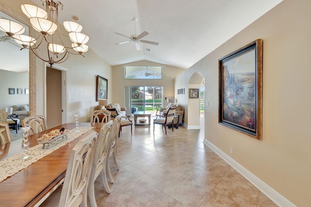 tiled dining space featuring ceiling fan with notable chandelier and vaulted ceiling