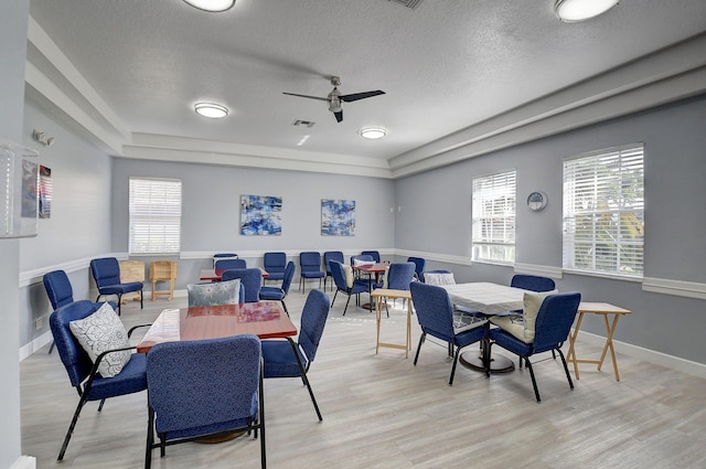 dining room with ceiling fan, plenty of natural light, and light hardwood / wood-style floors