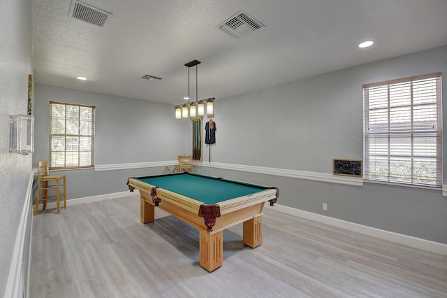 game room with light hardwood / wood-style floors, a textured ceiling, and billiards