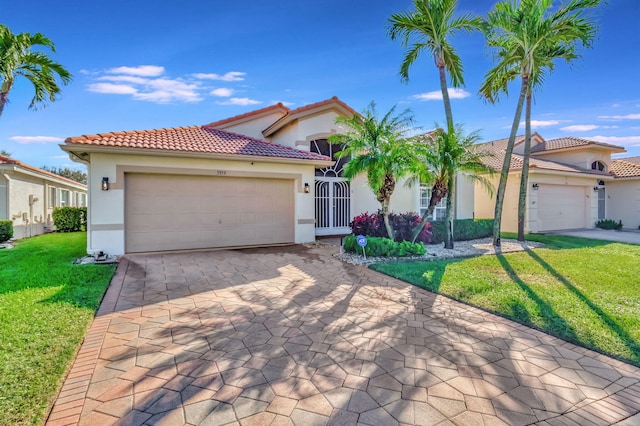 mediterranean / spanish-style house with a garage and a front lawn