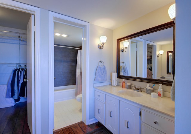 full bathroom featuring hardwood / wood-style floors, vanity, toilet, and shower / bath combo