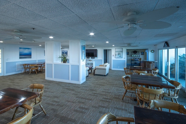 carpeted dining room with a paneled ceiling and ceiling fan